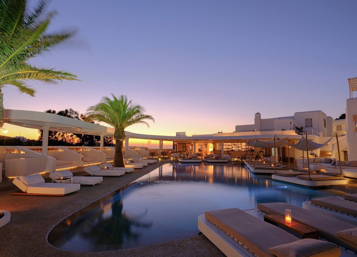 Mykonos Town at dusk — iconic white-washed windmills and Cycladic architecture above the Aegean Sea